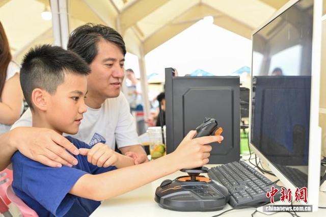 图为小朋友在嘉年华上体验模拟飞行。中新社记者 陈骥旻 摄